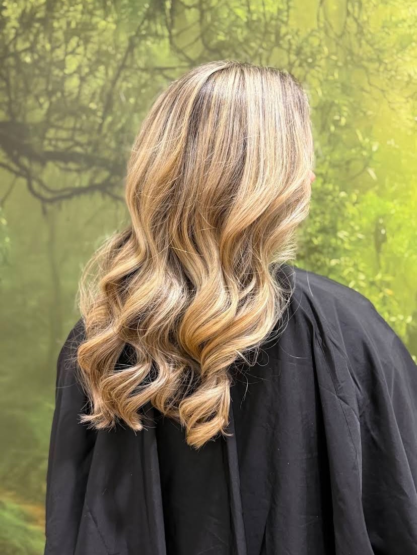 Balayage blond ondulé vu de dos au salon Viktorio
