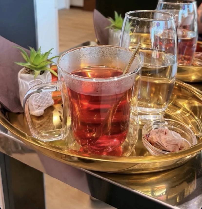Plateau doré avec thé et verre d'eau servi aux clients du salon Viktorio